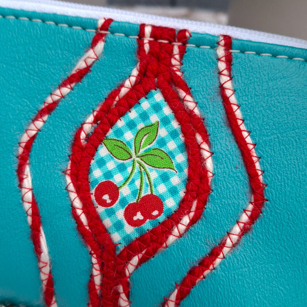 Sacred Fruit Teal Embroidered Vagina Vulva Wallet with Cherry Sweet Spot. Made by Anne Marie Beard. Handmade in Austin, Texas since 2002 y'all! annemarie yoni feminist divine feminine cherry picnic